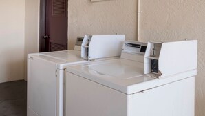 A laundry area with two stacked front-loading washing machines. - Red Roof Inn MacClenny (MacClenny)