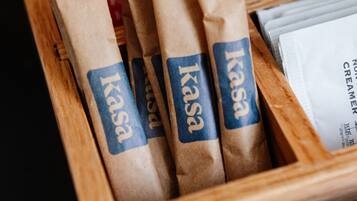 Een houten dienblad met verschillende bruine papieren zakken, gelabeld met 'Kasa' en 'Demetra Suiker'.