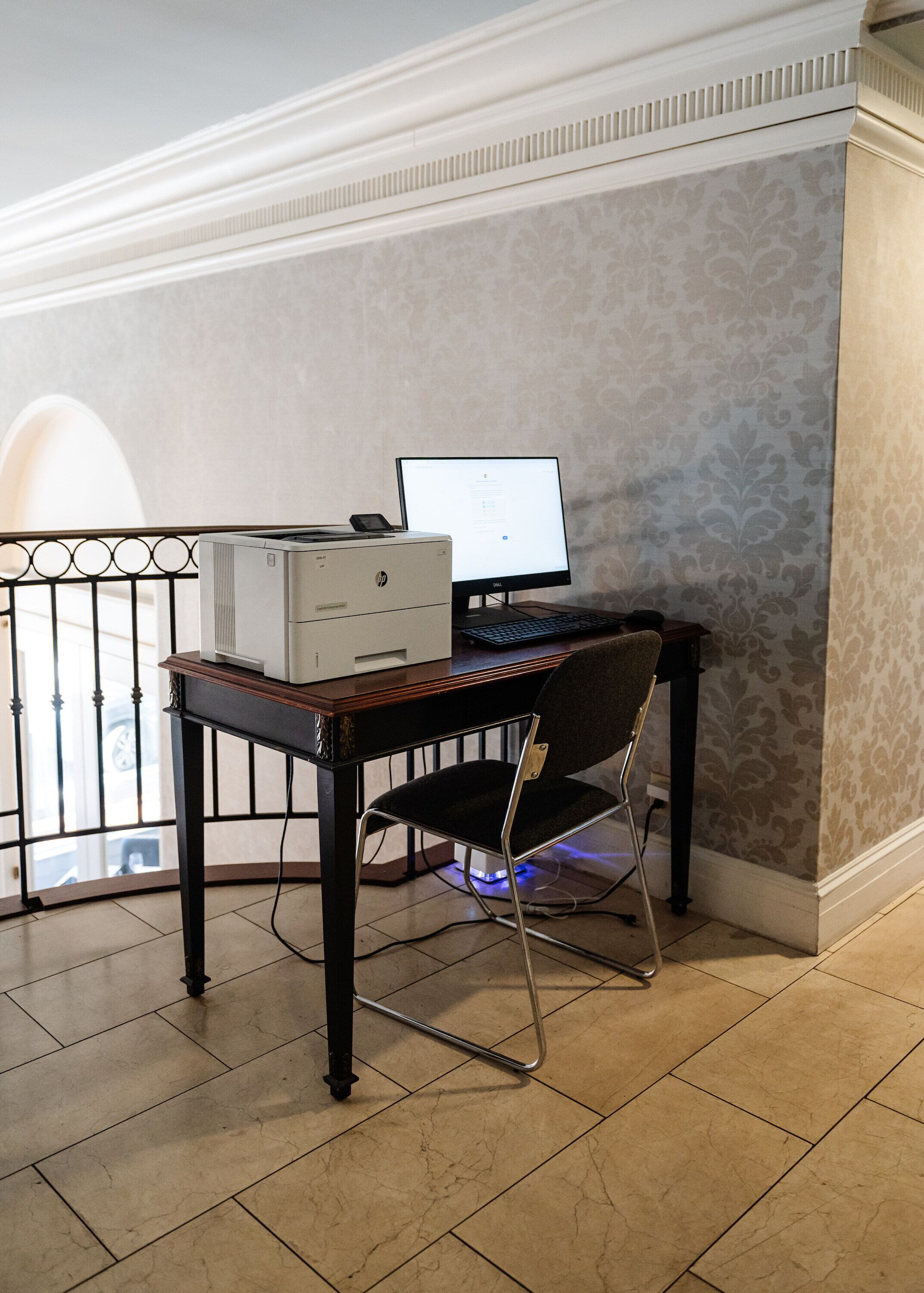 Un espacio de trabajo con un ordenador de escritorio, una impresora y una silla.