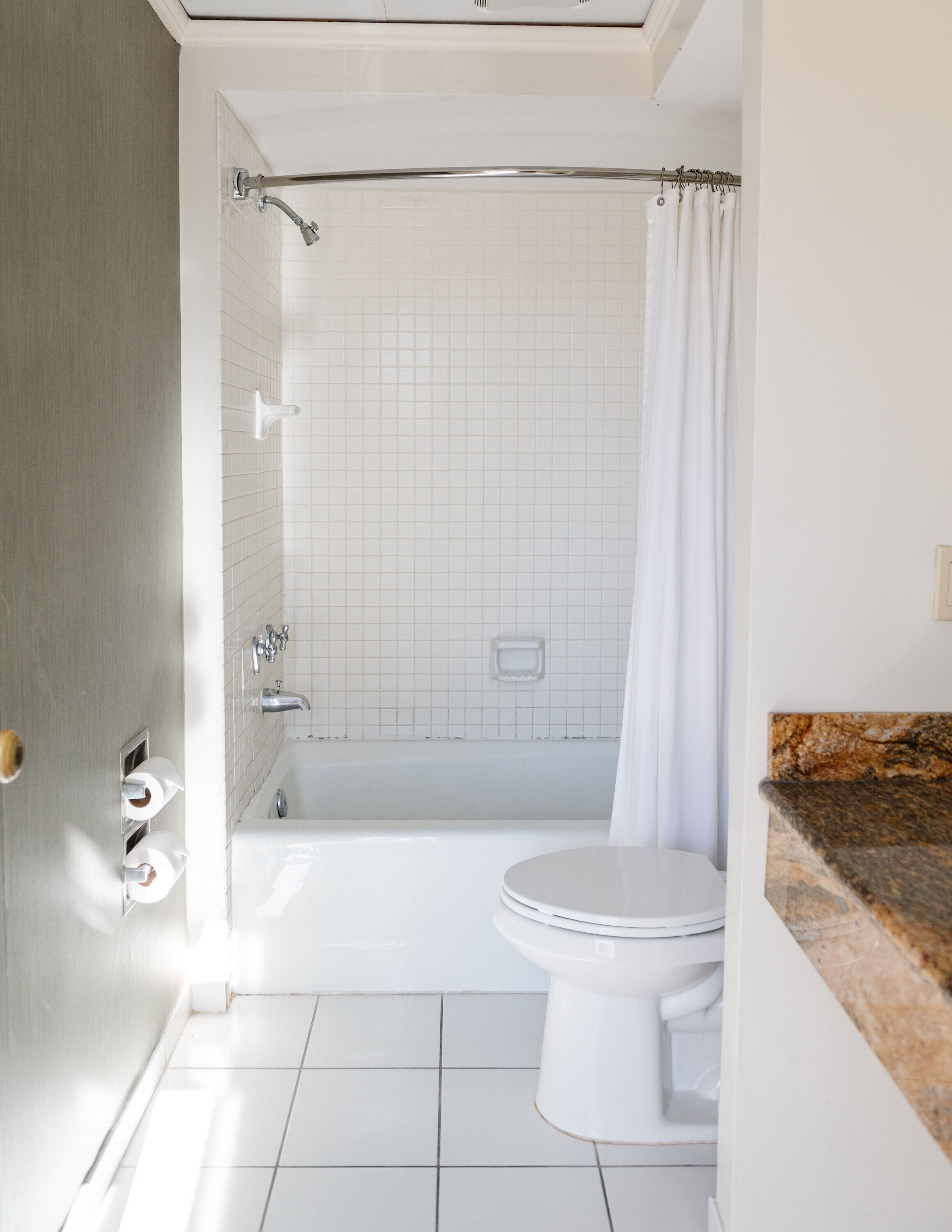 Un baño con bañera, inodoro y cortina de ducha.