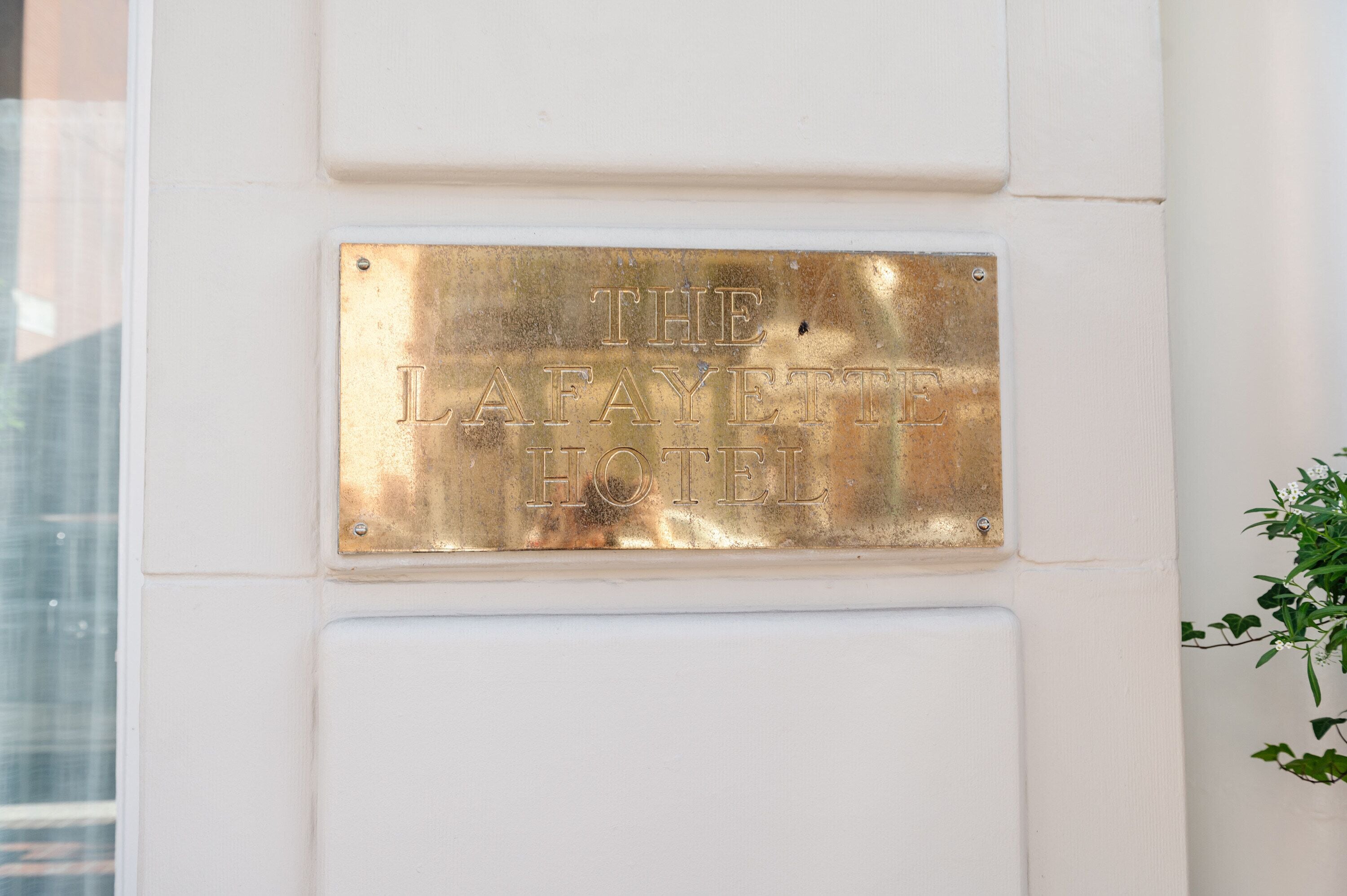 A plaque on a wall that reads "THE LAFAYETTE HOTEL".