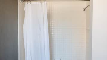 A bathroom with a bathtub, toilet, and a shower curtain.