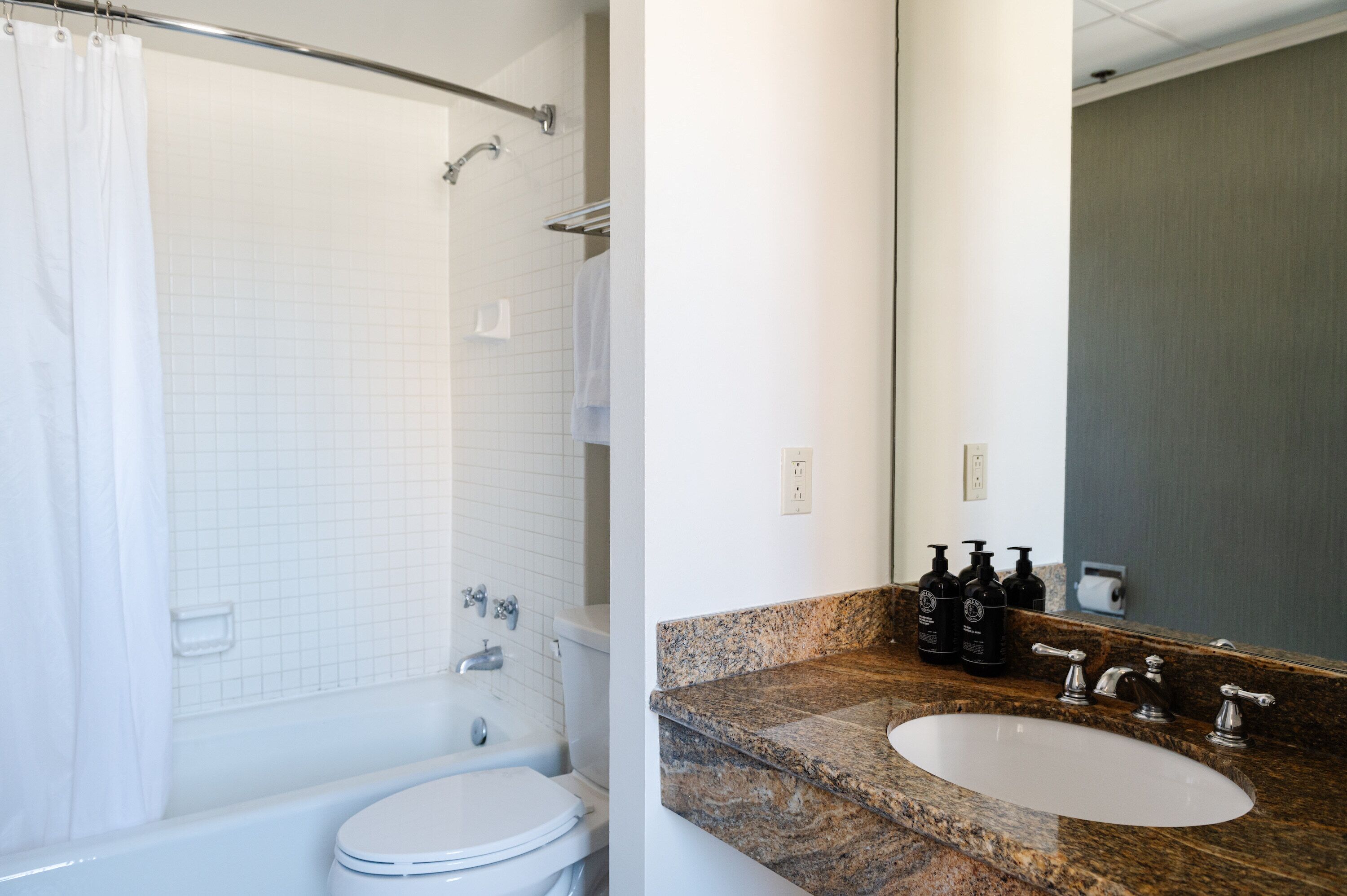 Een badkamer met douche, toilet en wastafel.