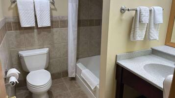 A bathroom with a toilet, a bathtub, and a sink.