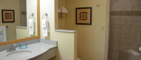 Ein Badezimmer mit Waschbecken, Spiegel, Toilette und Dusche.