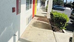 A smoke-free building exterior with a covered walkway, a mailbox, and a palm tree in the background.