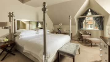 Un dormitorio con cama con dosel, una silla, un aparador y una ventana con cortinas.
