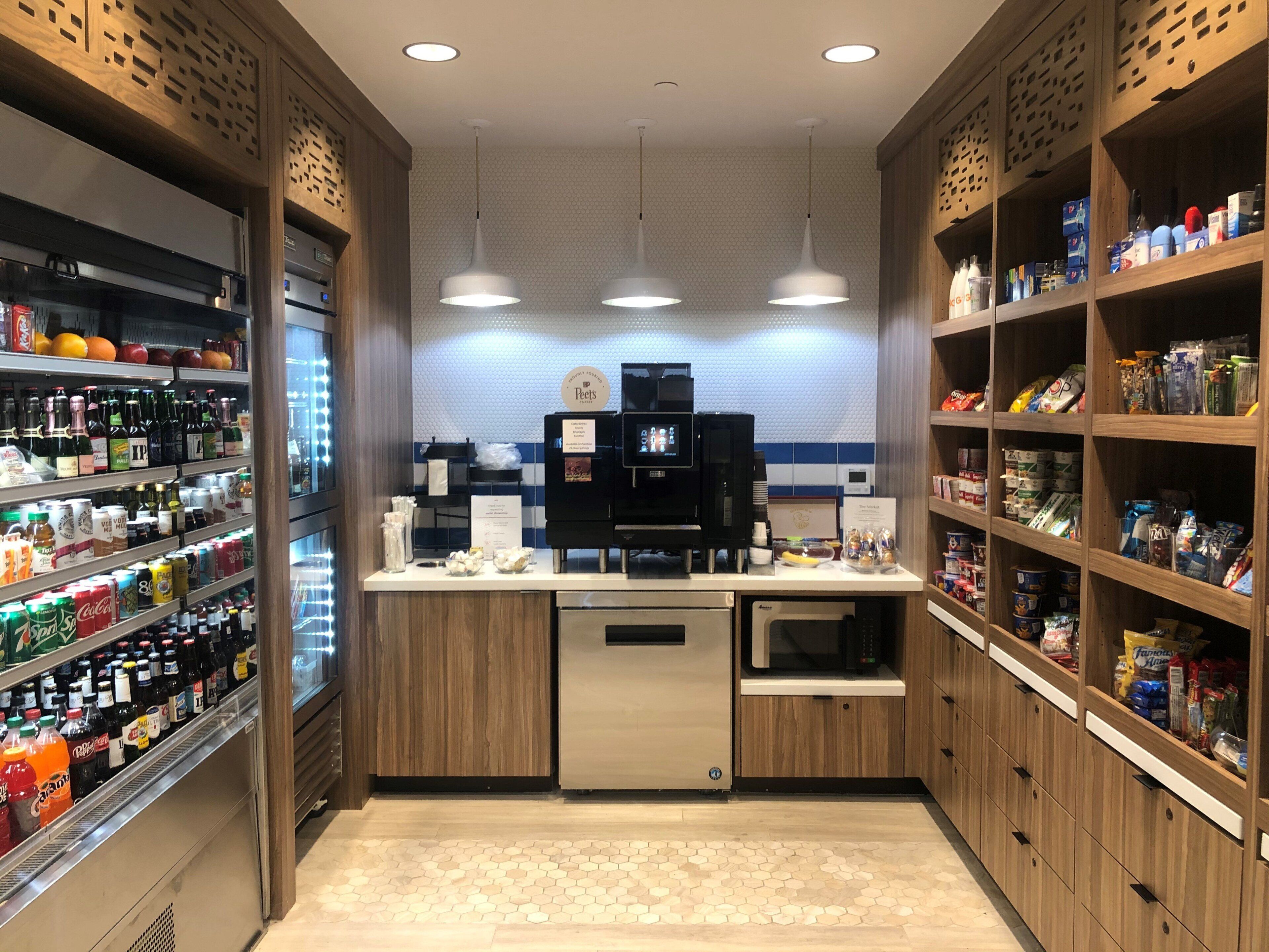 Un espace de libre-service proposant des boissons fraîches, une machine à café et un four à micro-ondes.