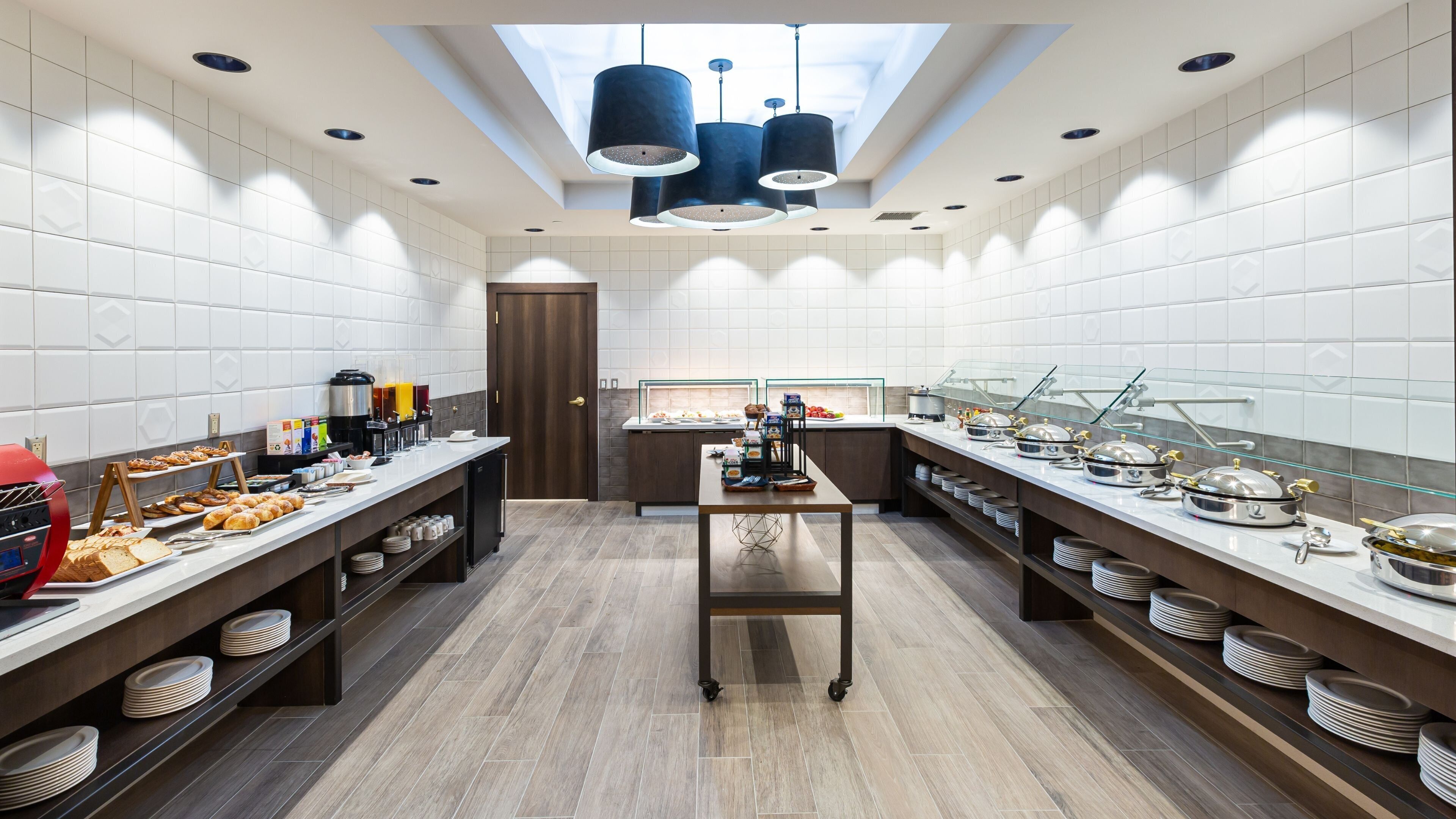 A modern kitchen with a central island, breakfast bar, and buffet area.