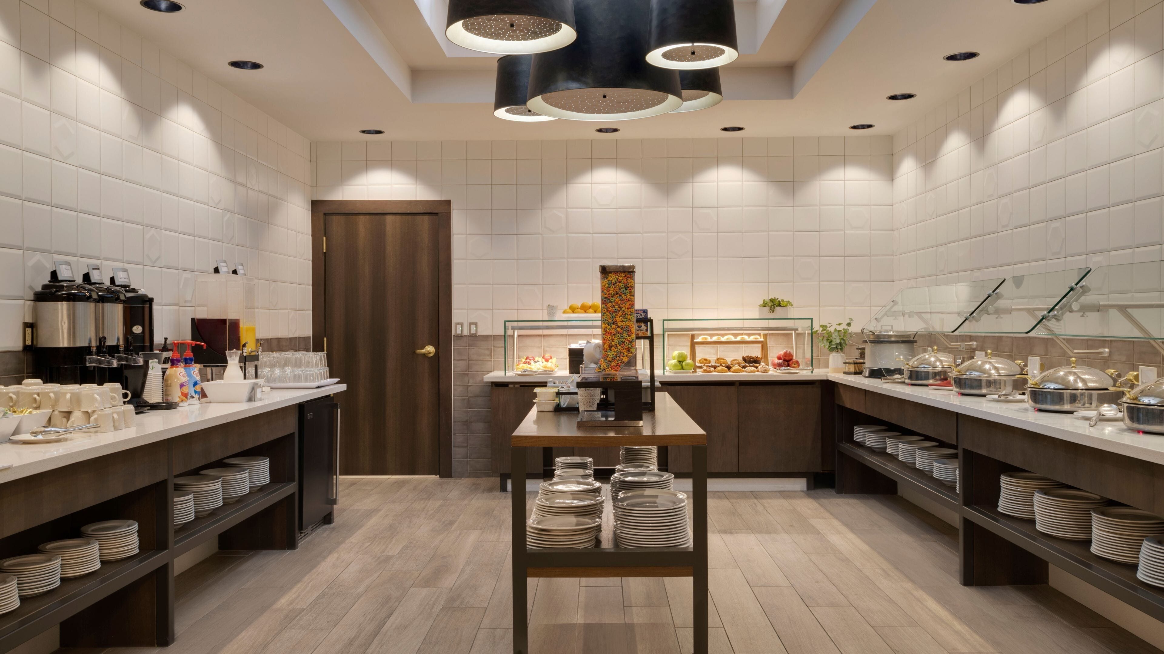 A modern kitchen with two service counters, a coffee station, and a buffet area.