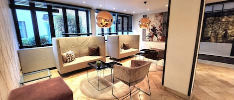 Una sala de estar moderna con un sofá, sillones, una mesa de centro y una chimenea.