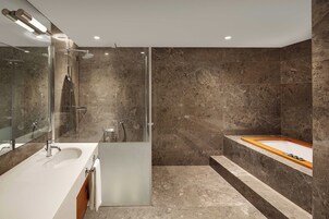 Un baño moderno con ducha de vidrio, un lavamanos grande y una bañera independiente.