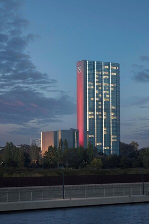 Ein modernes Hochhaus mit auffälliger vertikaler roter Linie und spiegelnden Glasfenstern.