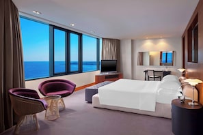 A modern hotel room with a large window, a bed, a TV, a desk, and two chairs. - Sheraton Istanbul Atakoy Hotel (Istanbul)