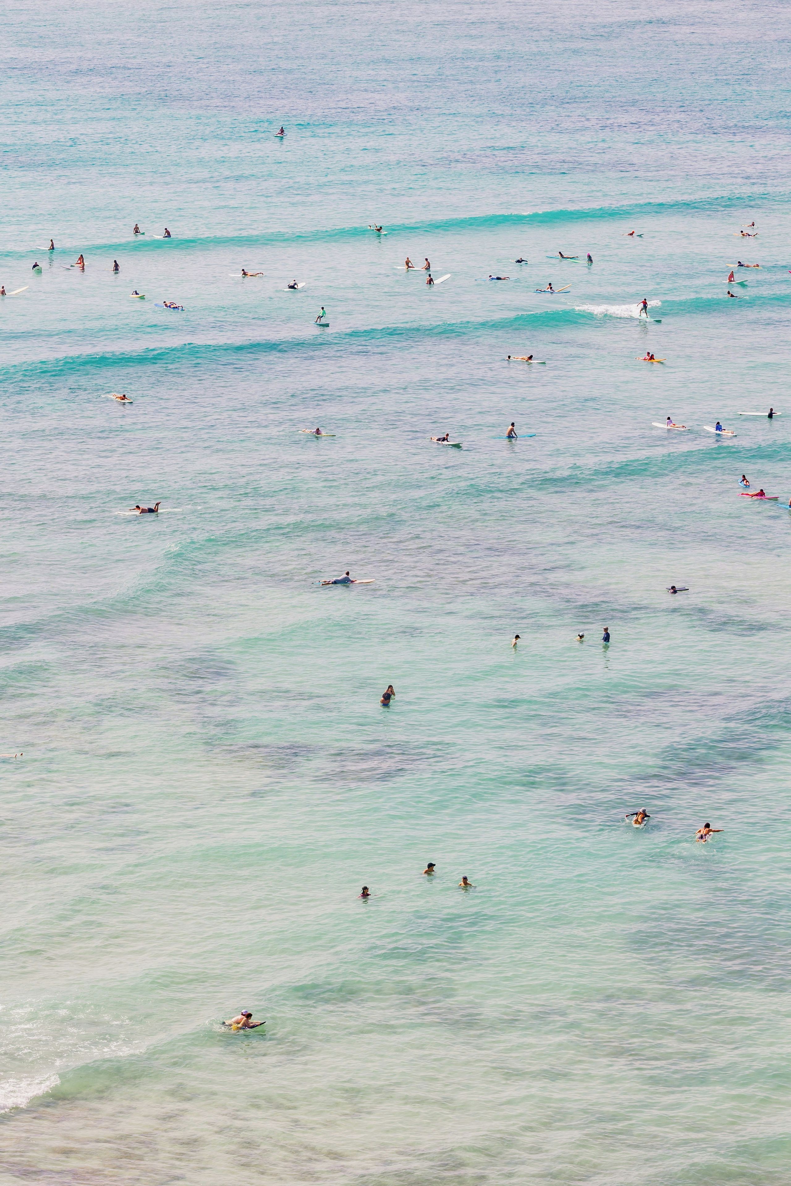 A beach with multiple people engaged in various water activities.