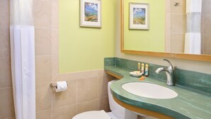 A bathroom with a toilet, sink, and shower curtain.
