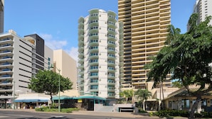 A multi-story hotel with a curved facade, multiple balconies, and a central entrance with a covered walkway.