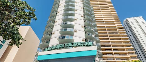 Un hotel moderno con un diseño angular único, varios balcones y vistas claras del paisaje urbano circundante.
