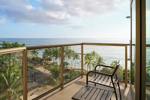 Ein Balkon mit Blick auf das Meer und Palmen.