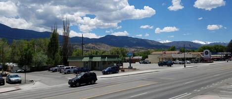 A street view with a gas station, a golf course sign, and mountains in the background.