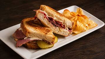 A plate with a grilled sandwich and potato chips.
