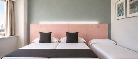 Habitación de hotel con una cama doble, una cama individual y vistas a la ciudad.