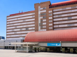 Un hotel de diseño moderno, con un techo rojo característico y un espacio de estar al aire libre cubierto.