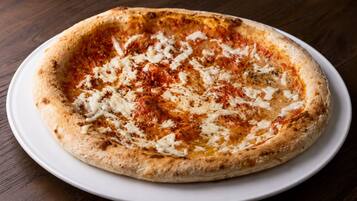 Una pizza sobre un plato blanco.
