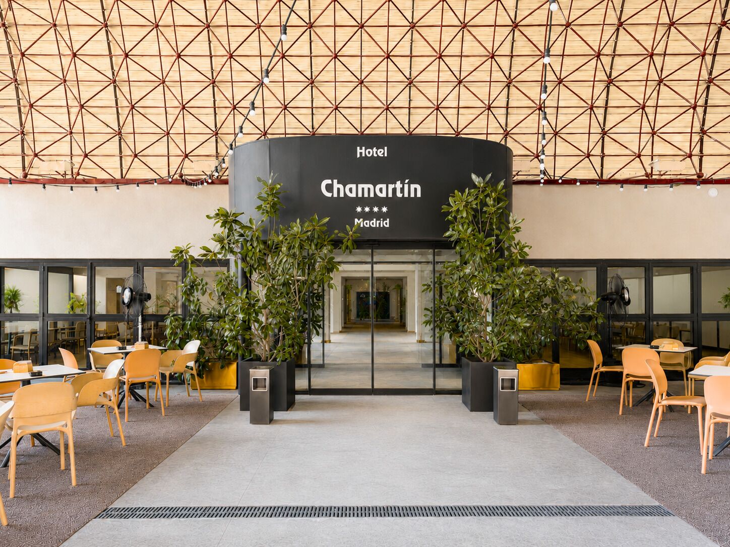 Entrada de un hotel con diseño moderno, destacando un cartel grande del Hotel Chamartin en Madrid.