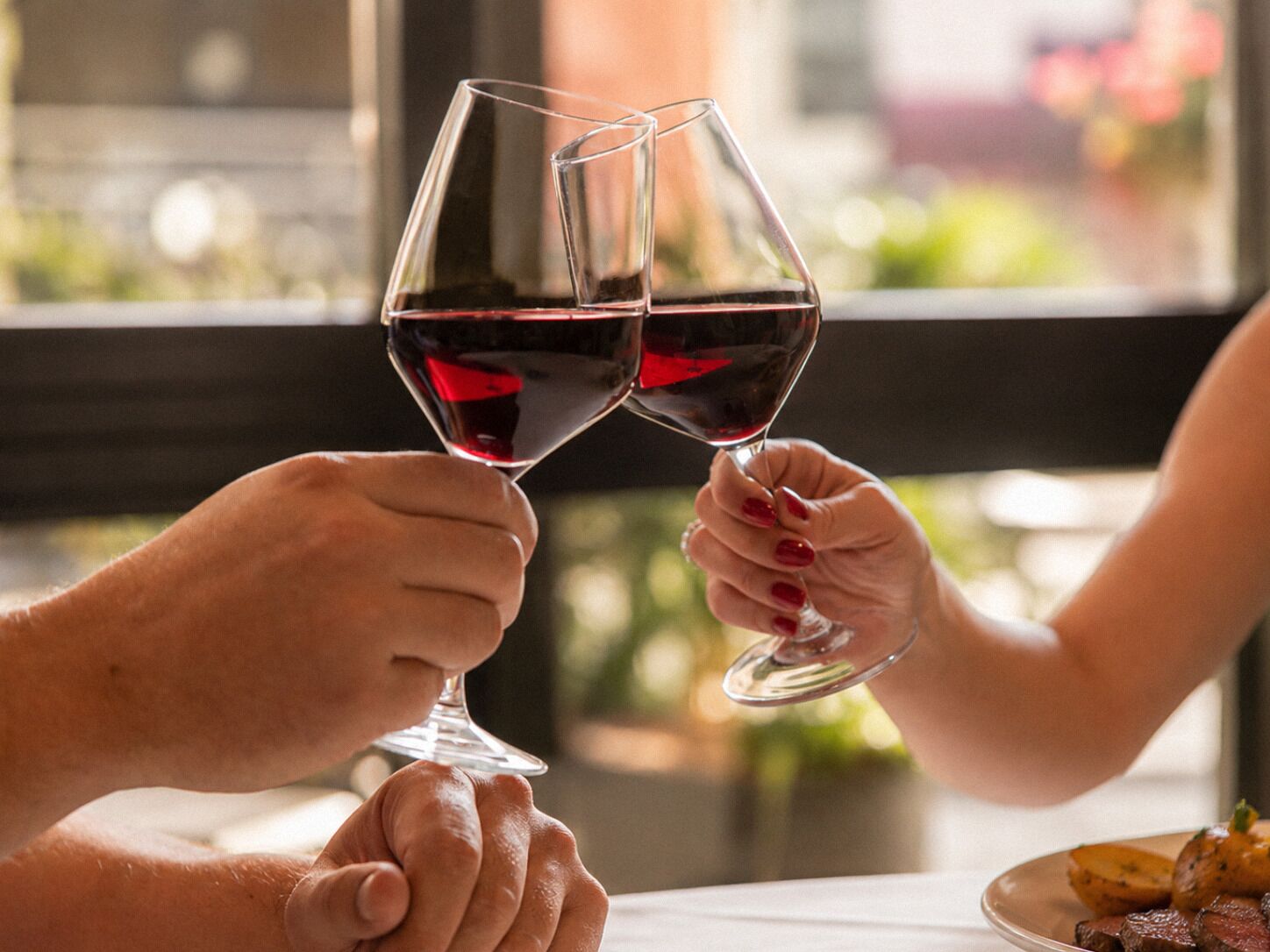 Dos personas brindando con copas de vino.