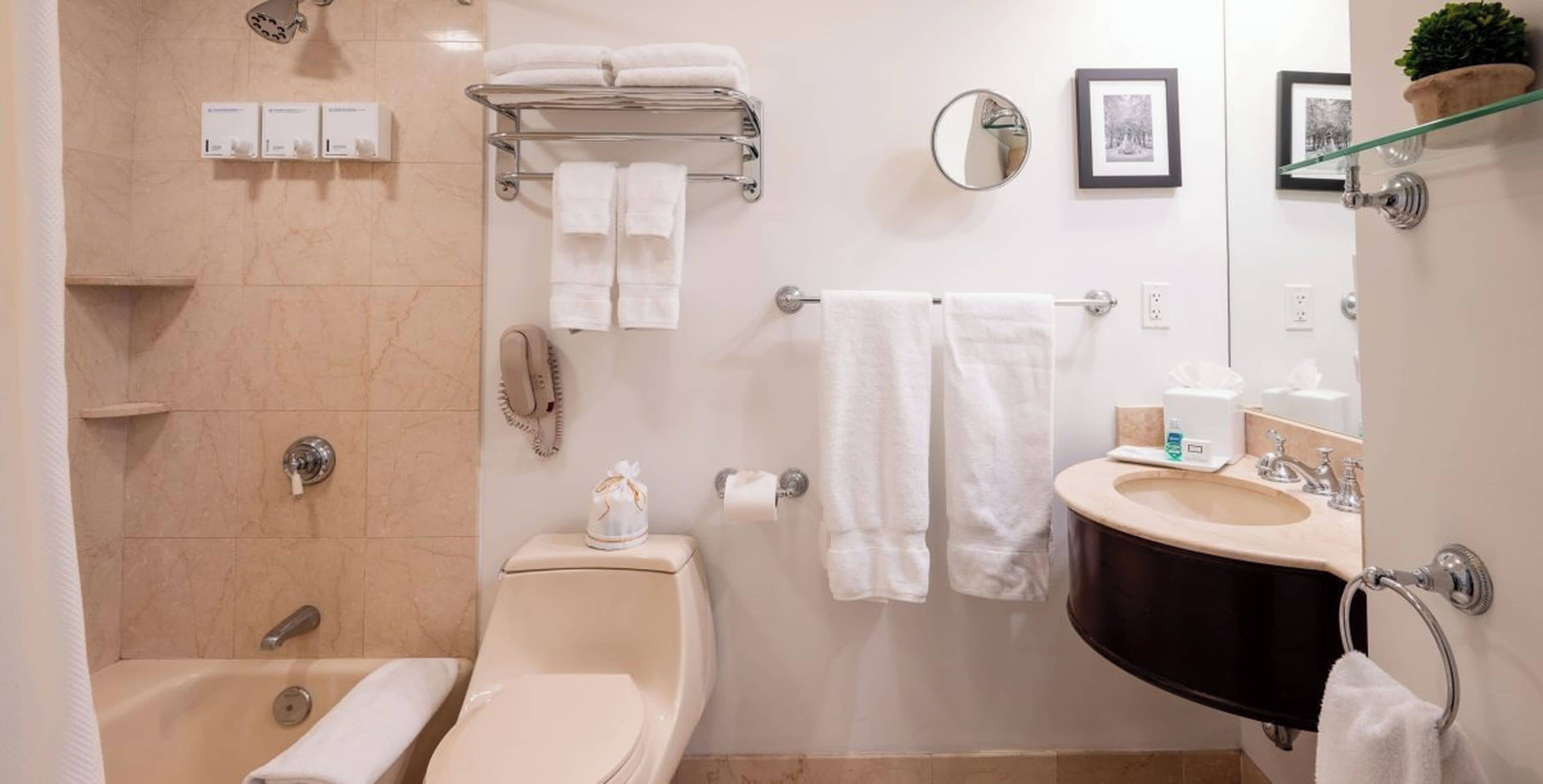 A bathroom with a bathtub, a sink, a toilet, and a shower area.
