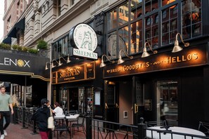 A restaurant named SWEENEYS with outdoor seating and a sign that reads "IRISH GOODBYES. JUST. HELLOS."