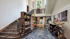 A spacious interior with a grand staircase, a motorcycle, and a collection of decorative items. - Le Méridien Frankfurt (Frankfurt)