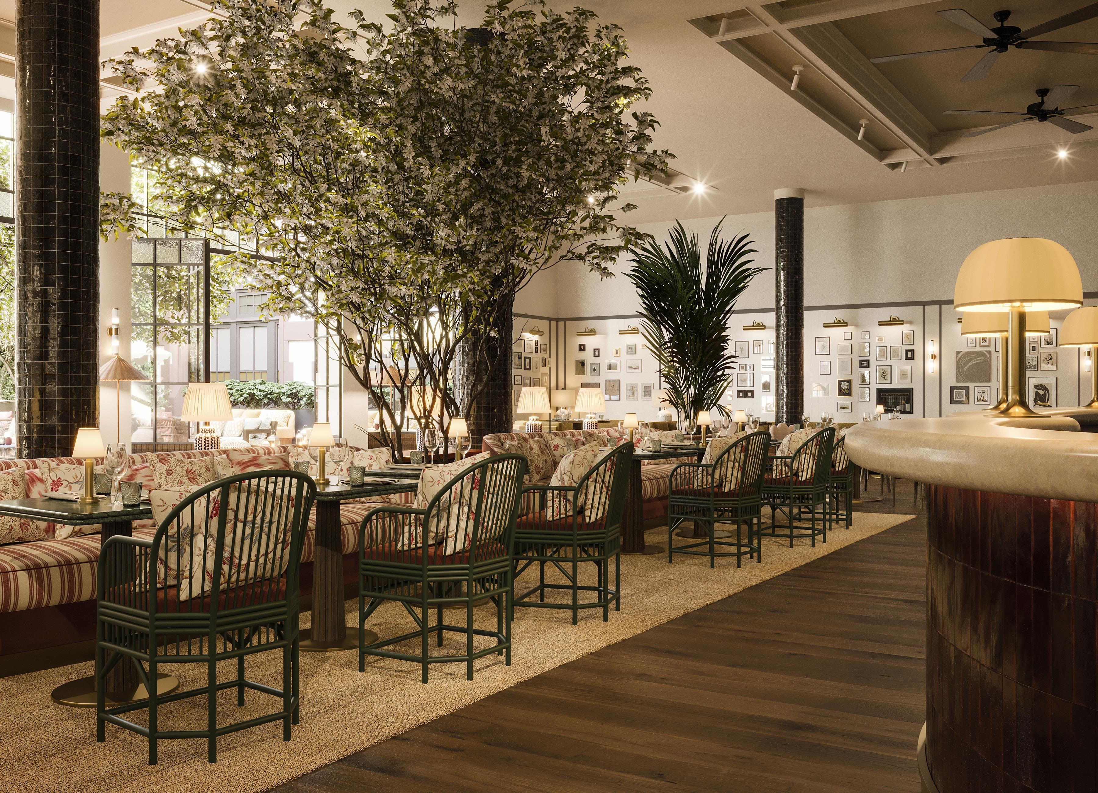 A hotel lobby with a seating area, a large tree, and a bar.