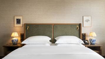A hotel room with a double bed, two bedside tables with lamps, and framed artwork on the walls.