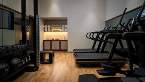 A gym with treadmills, a squat rack, and dumbbells.