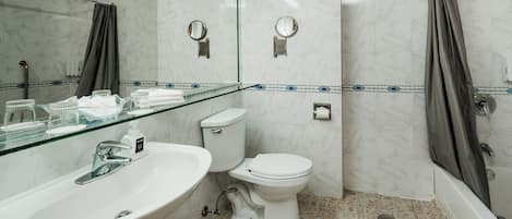 Un baño con lavamanos de cristal, inodoro y zona de ducha.