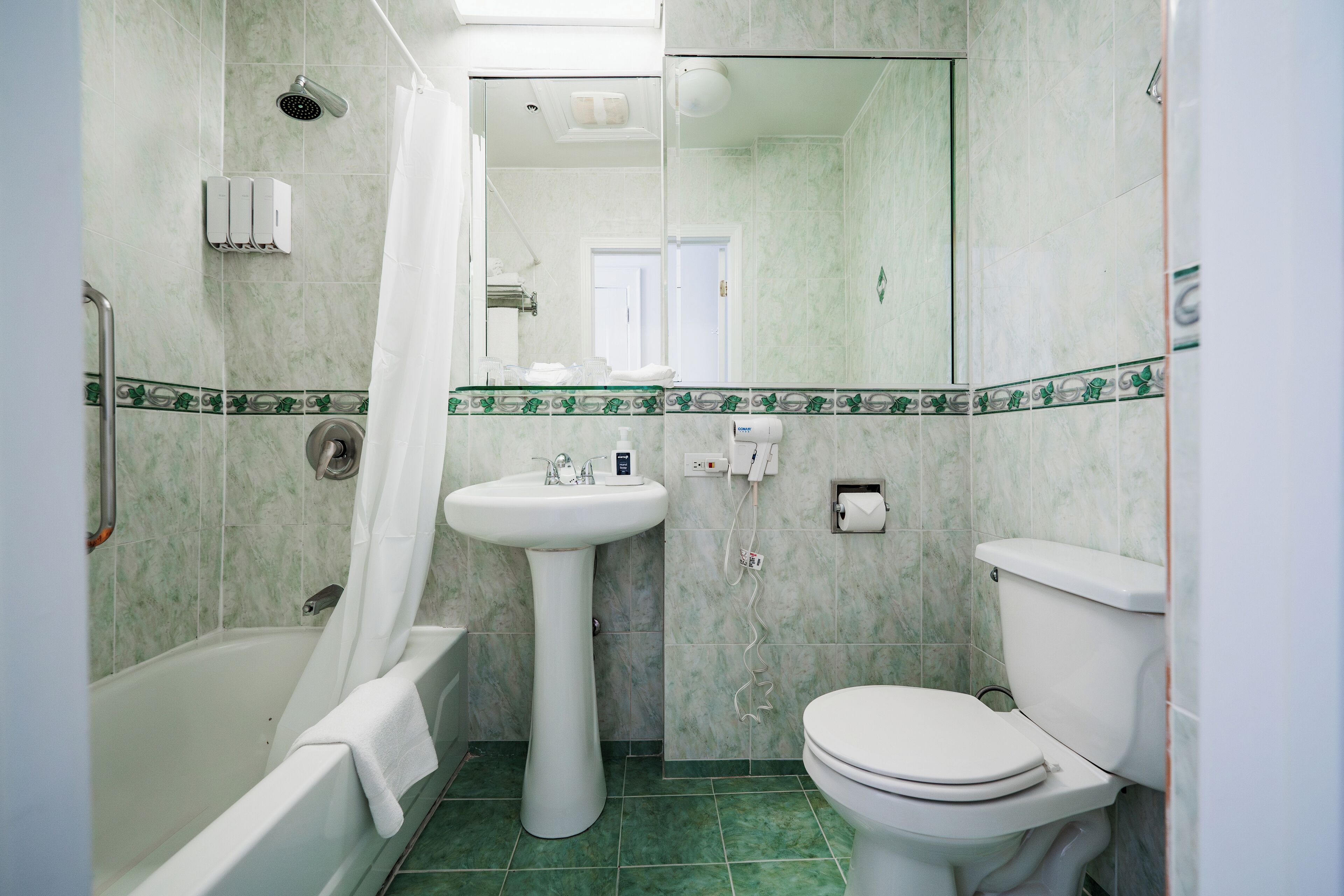 Een badkamer met een bad, wastafel en toilet.