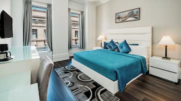 Une chambre d’hôtel moderne avec un grand lit, deux tables de chevet, un bureau et une chaise.