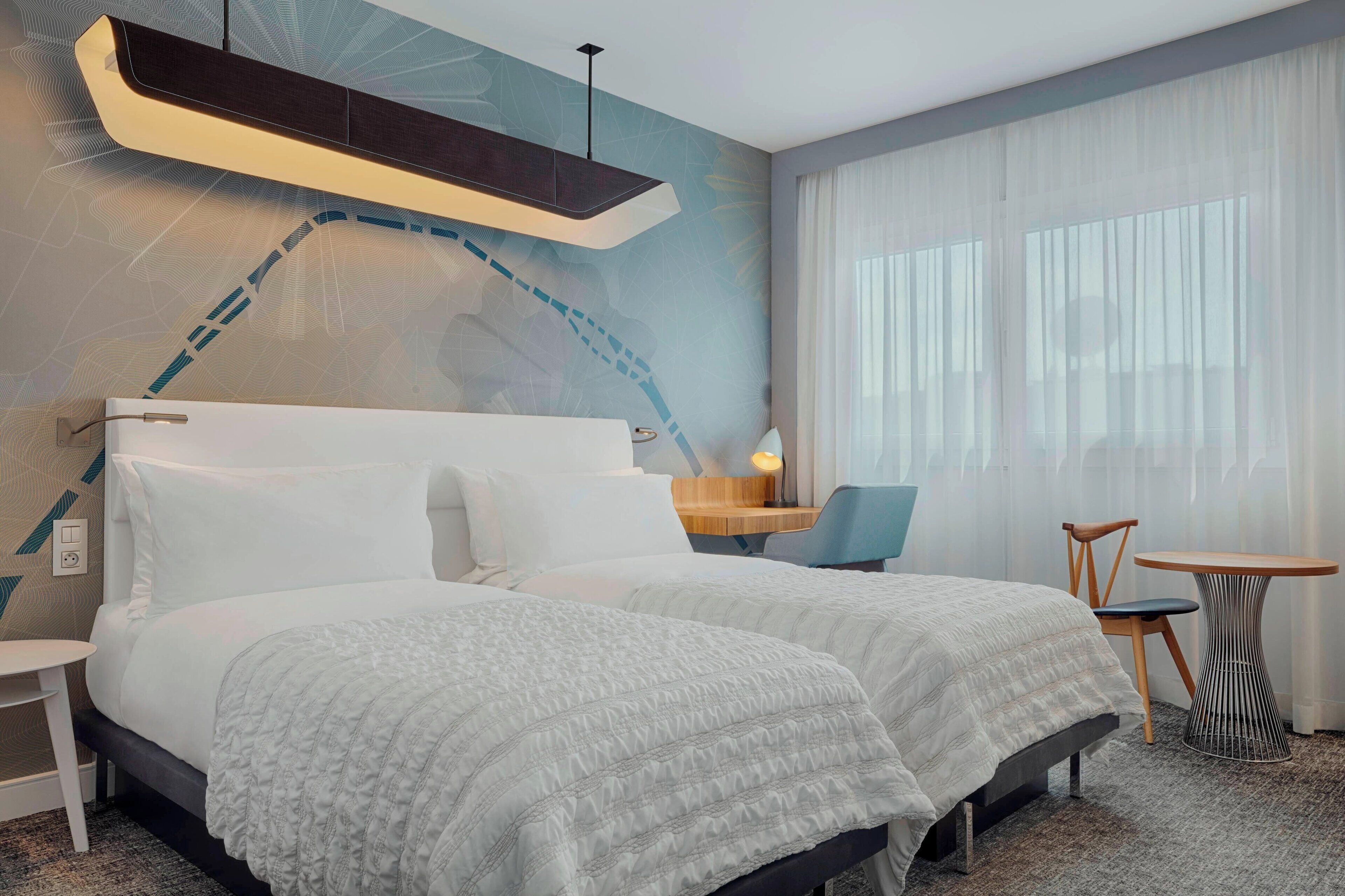 Une chambre d’hôtel avec un grand lit, un bureau, une chaise et une petite table.