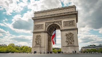 Un arco de piedra grande con intrincados grabados y una bandera en el centro.
