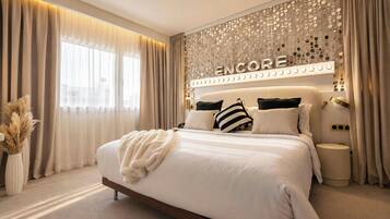 A modern bedroom with a large bed, a decorative headboard, and a wall-mounted light fixture.