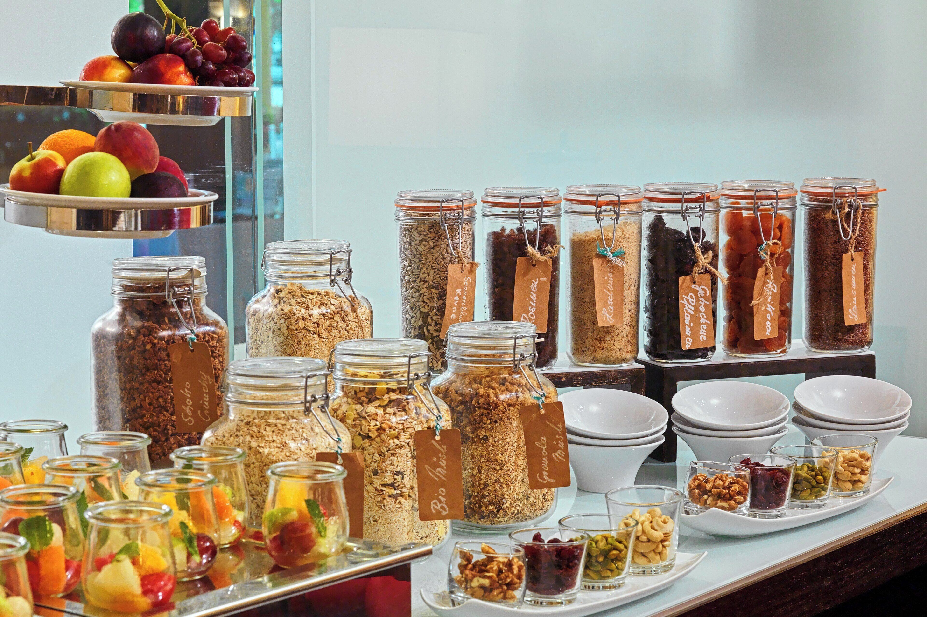 A buffet with various food items, including fruits, granola, and nuts.