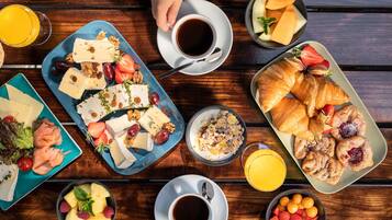 Una mesa de madera con una variedad de alimentos y bebidas para el desayuno.