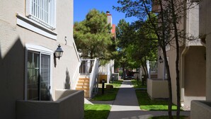 A residential street with houses, a sidewalk, and trees.