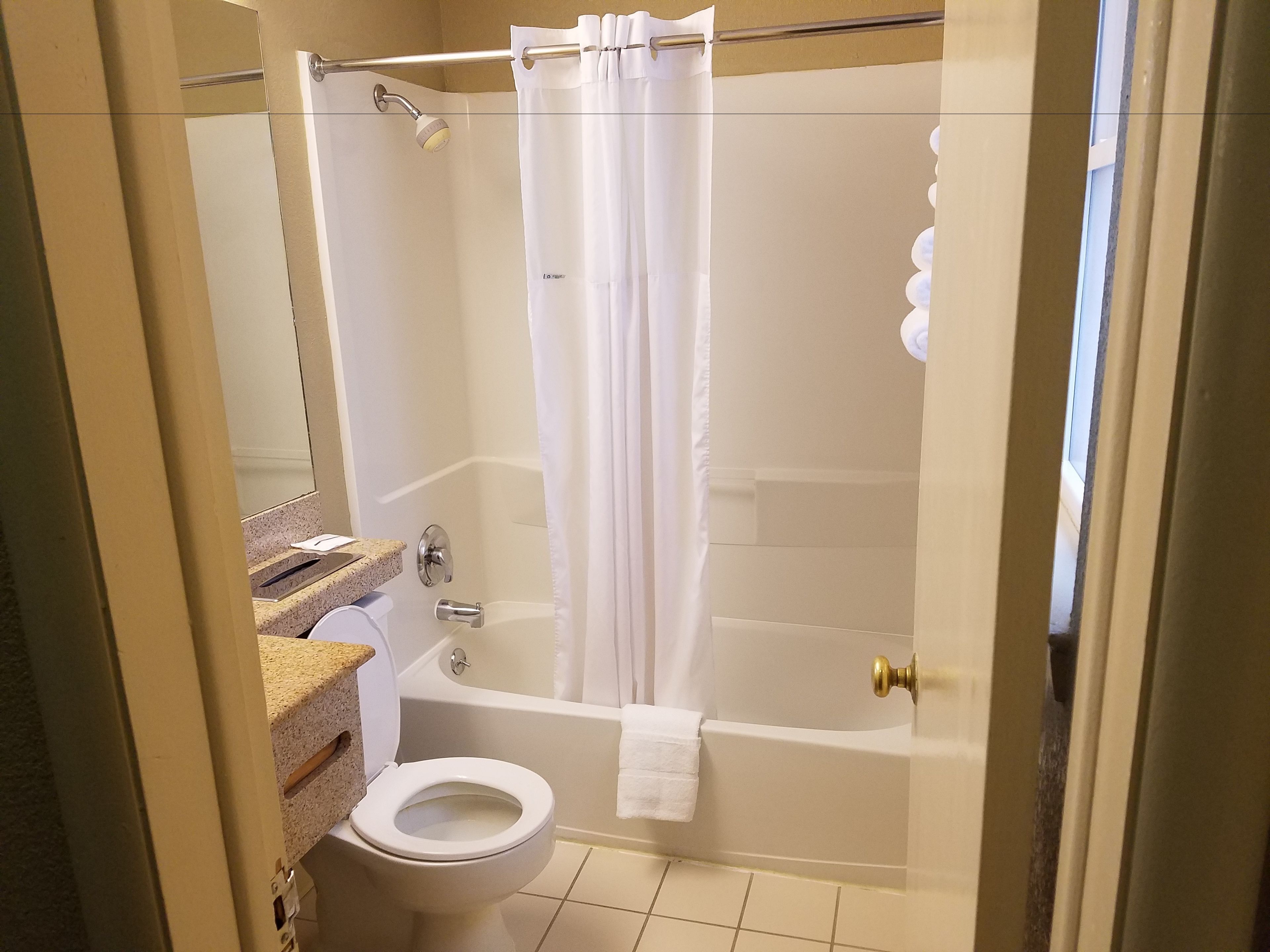 Et badeværelse med et brusekabine med glasvægge, toilet og badekar.