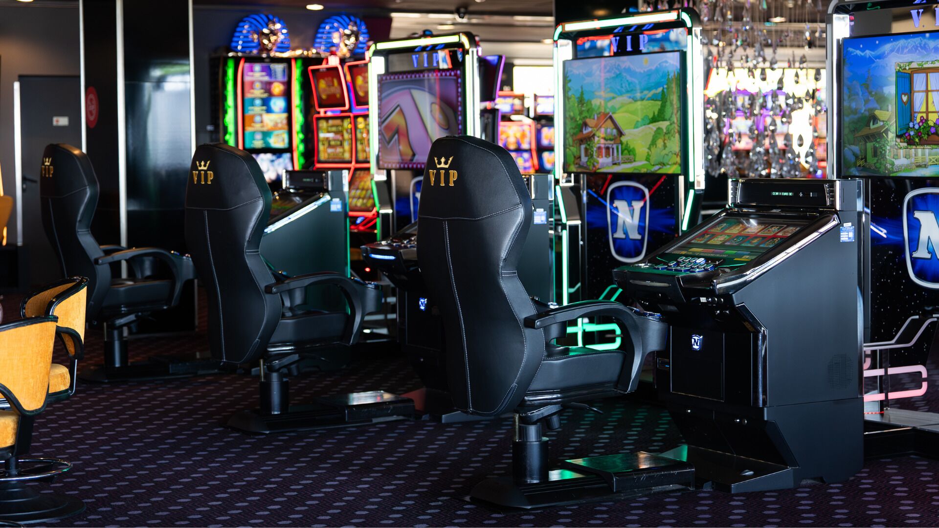 A gaming area with multiple slot machines, two VIP gaming stations, and a selection of chairs.