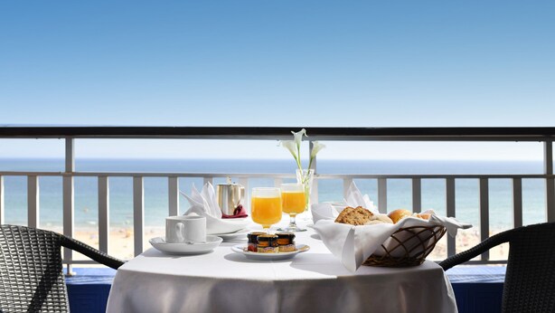 A table set for breakfast with a view of the ocean.