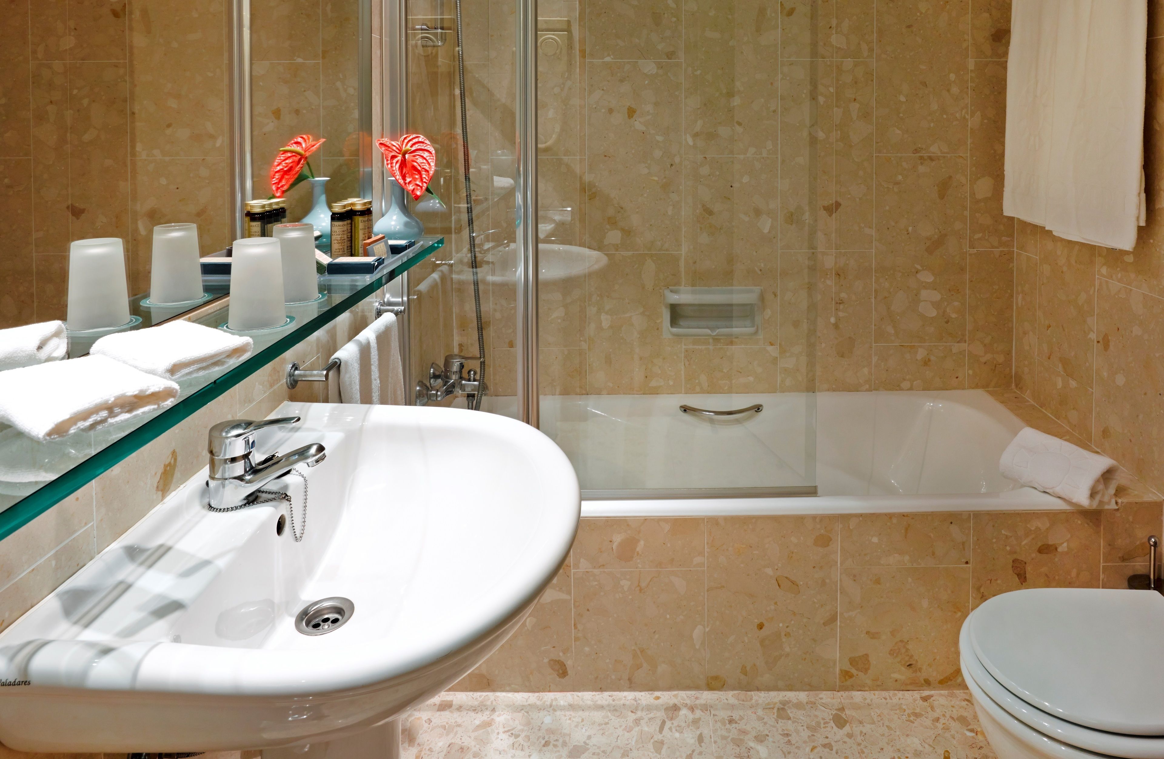 Une salle de bain avec une douche à parois de verre, un lavabo blanc et une baignoire.