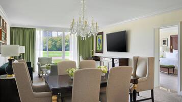 Un comedor con candelabro, televisor y vistas al exterior.